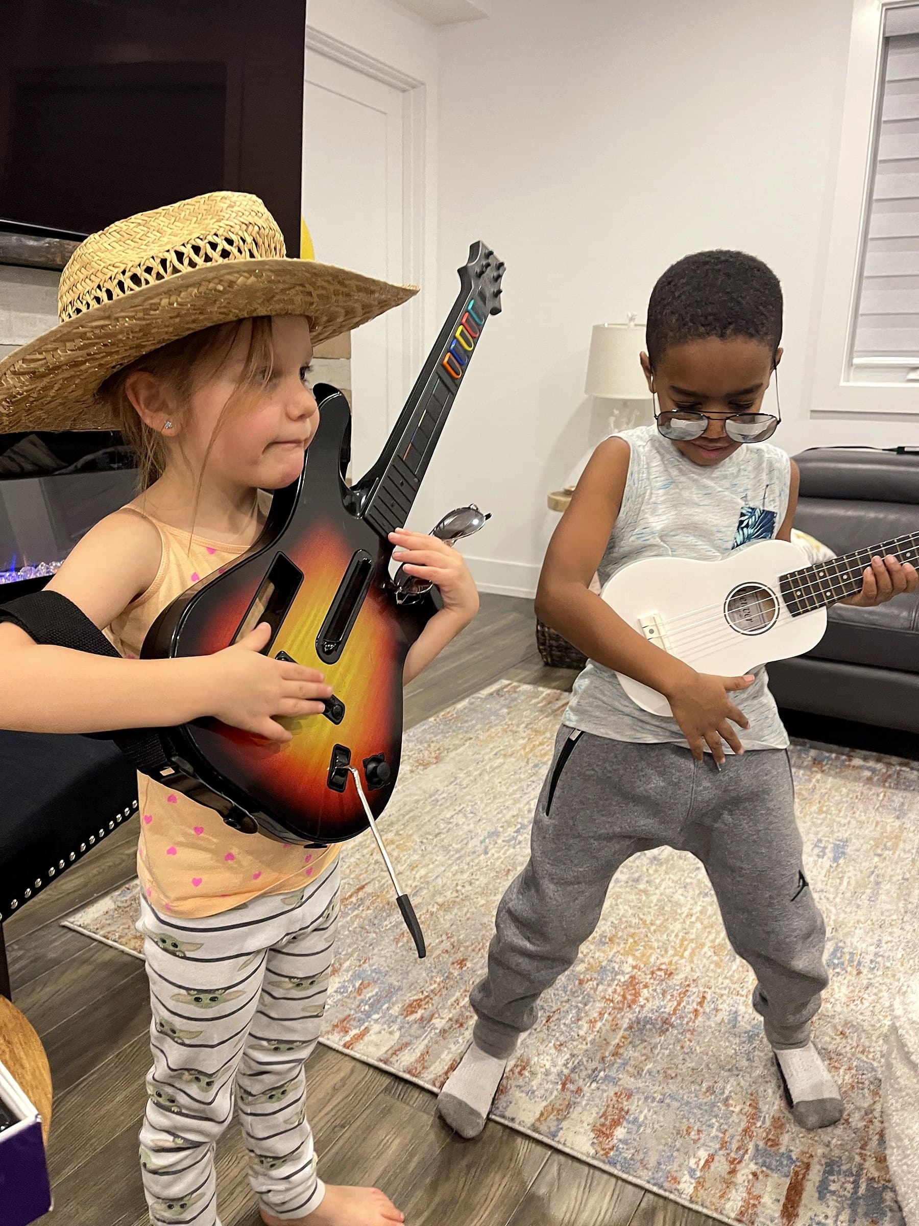 Two young children playing toy guitars in the main living room