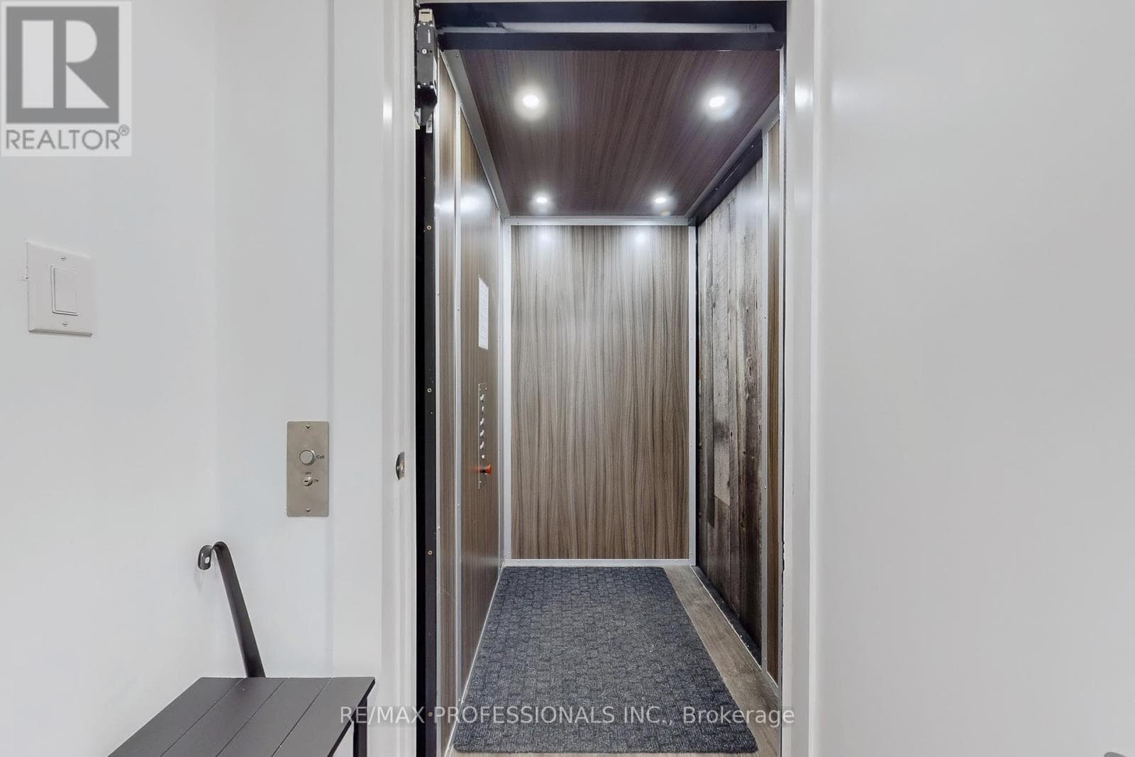 The private residential elevator inside the home, with wood-panelled interior and call button