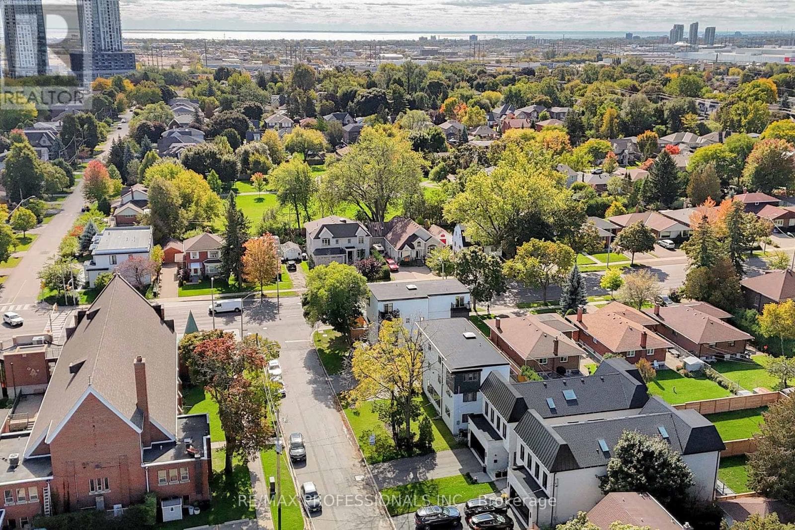 An aerial view over the leafy Etobicoke neighbourhood with the Toronto skyline on the horizon